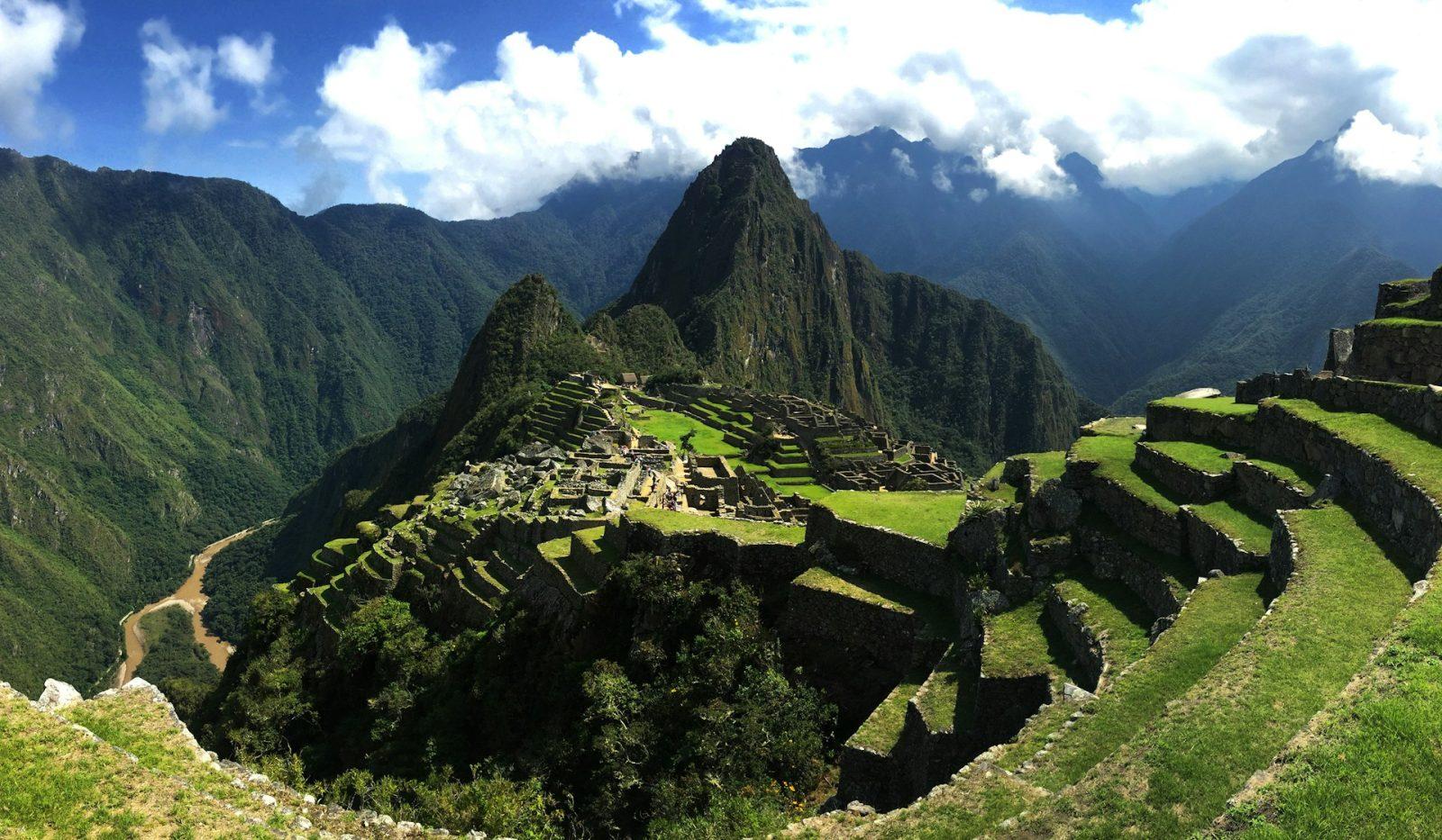 Foto de Machu Picchu com ruinas e uma montanha ao fundo.