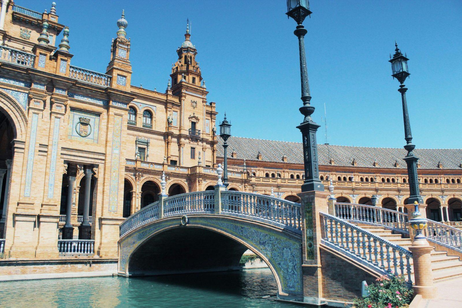 Foto de uma ponte com edificio atrás na Plaza España em Sevilha