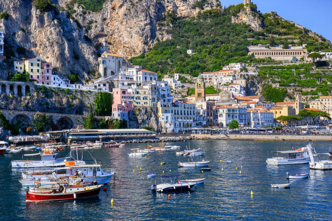 Foto paisagem da Costa de Amalfi, Itália. Barcos na agua e casas coloridas na encosta